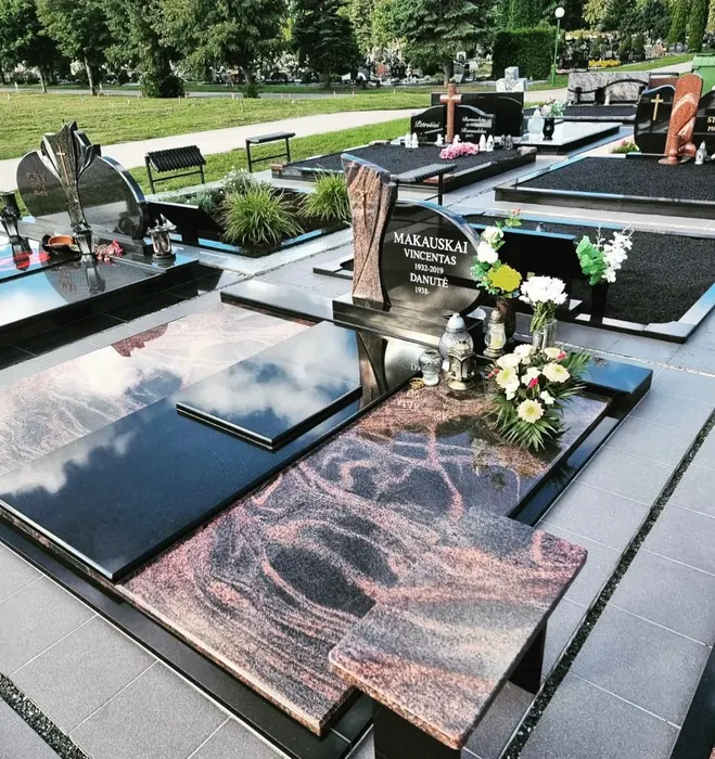 Dvivietis juodo granito antkapis su graviruotu užrašu ir raudono granito plokštėmis